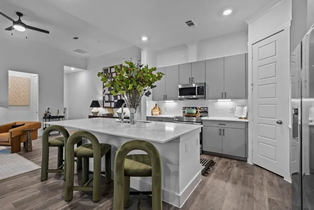 a kitchen with sink a refrigerator and chairs