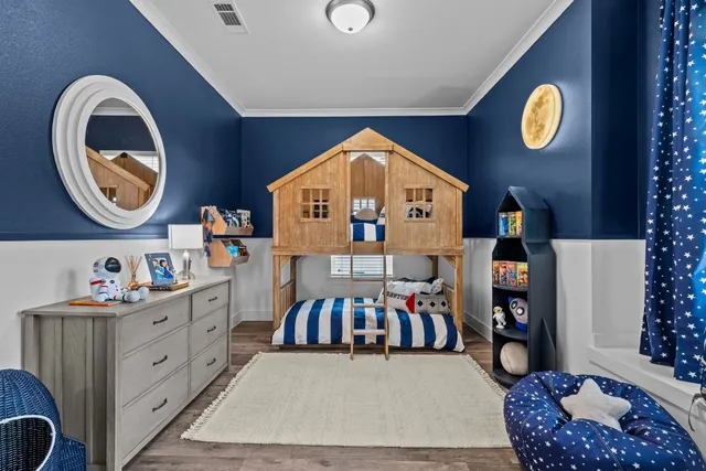 a bedroom with a bed and a lamp on dresser