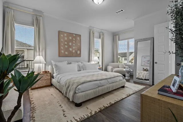 a spacious bedroom with a bed a couch and potted plant