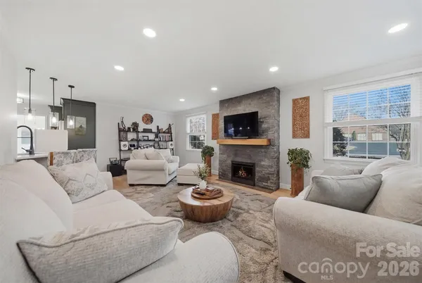 a living room with furniture a fireplace and a flat screen tv