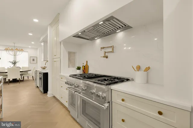 a dining room with chandelier and wooden floor