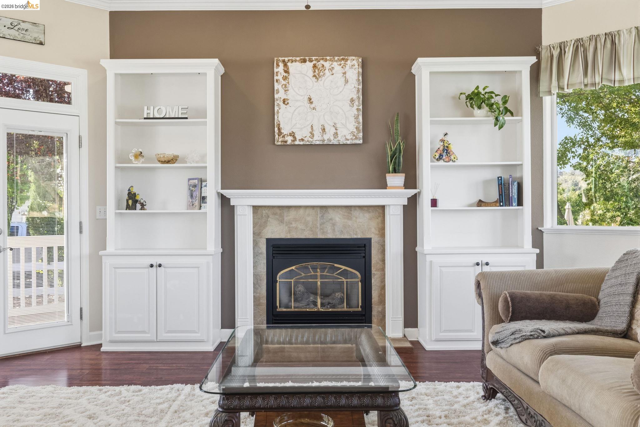 6242 Bluff View Road Copperopolis, CA 95228 - Photo 12 of 59 Living area featuring a fireplace with a stone surround and white mantelpiece, flanked by two built-in white shelving units