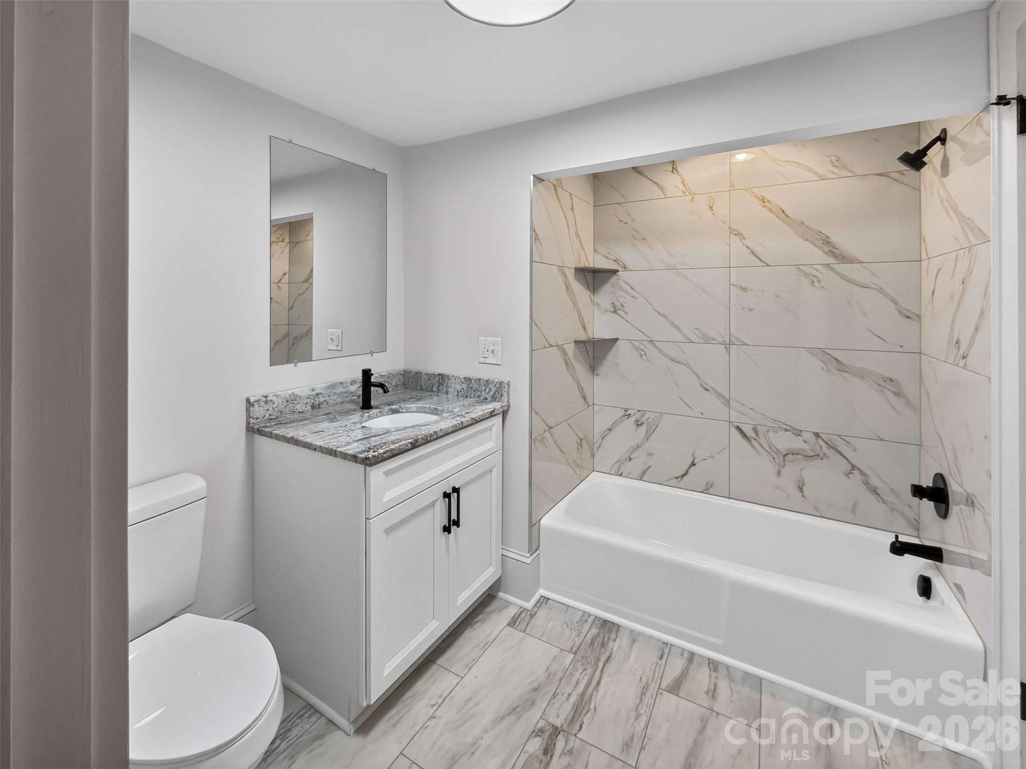 262 Pleasant Street Spindale, NC 28160 - Photo 18 of 37 a bathroom with a granite countertop sink a toilet and bathtub