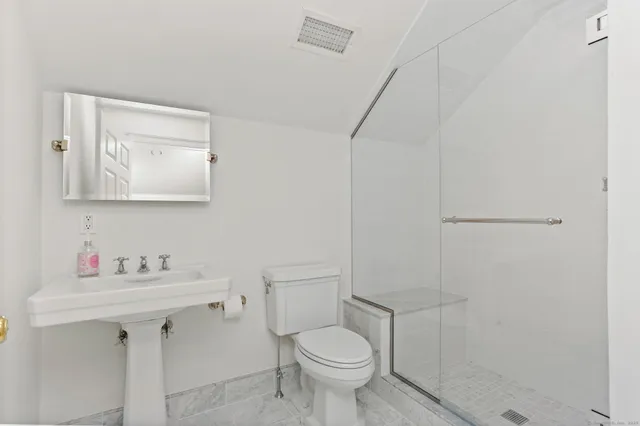 a bathroom with a toilet sink and mirror