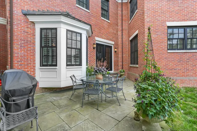 a view of a chair and table in the back yard of the house