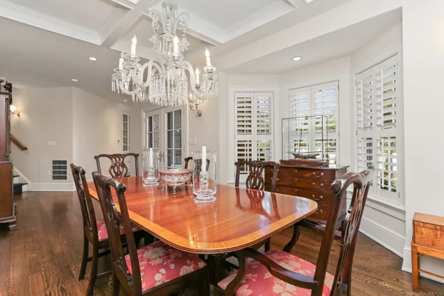 a dining room with furniture a chandelier and wooden floor