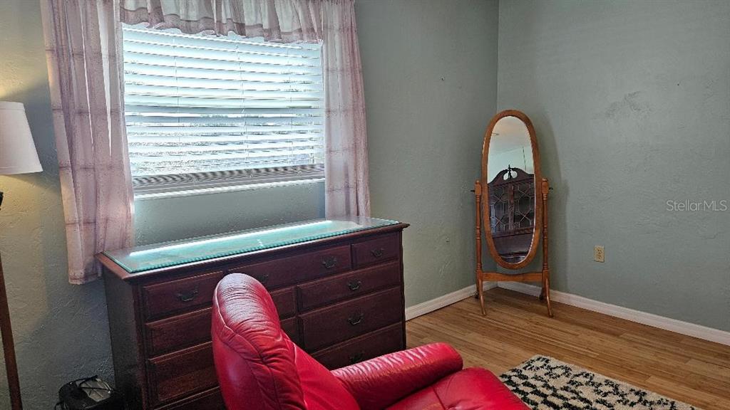 4600 98th Way North, Unit 210 St. Petersburg, FL 33708 - Photo 18 of 33 a room with a chair and large windows
