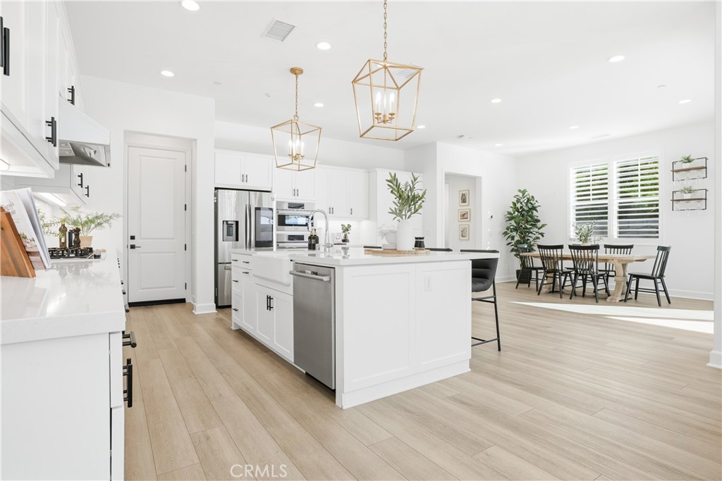 135 Medano Street Rancho Mission Viejo, CA 92694 - Photo 11 of 67 a large white kitchen with lots of counter space a sink and appliances