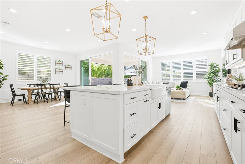 135 Medano Street Rancho Mission Viejo, CA 92694 - Photo 13 of 67 a large white kitchen with a large window and furniture
