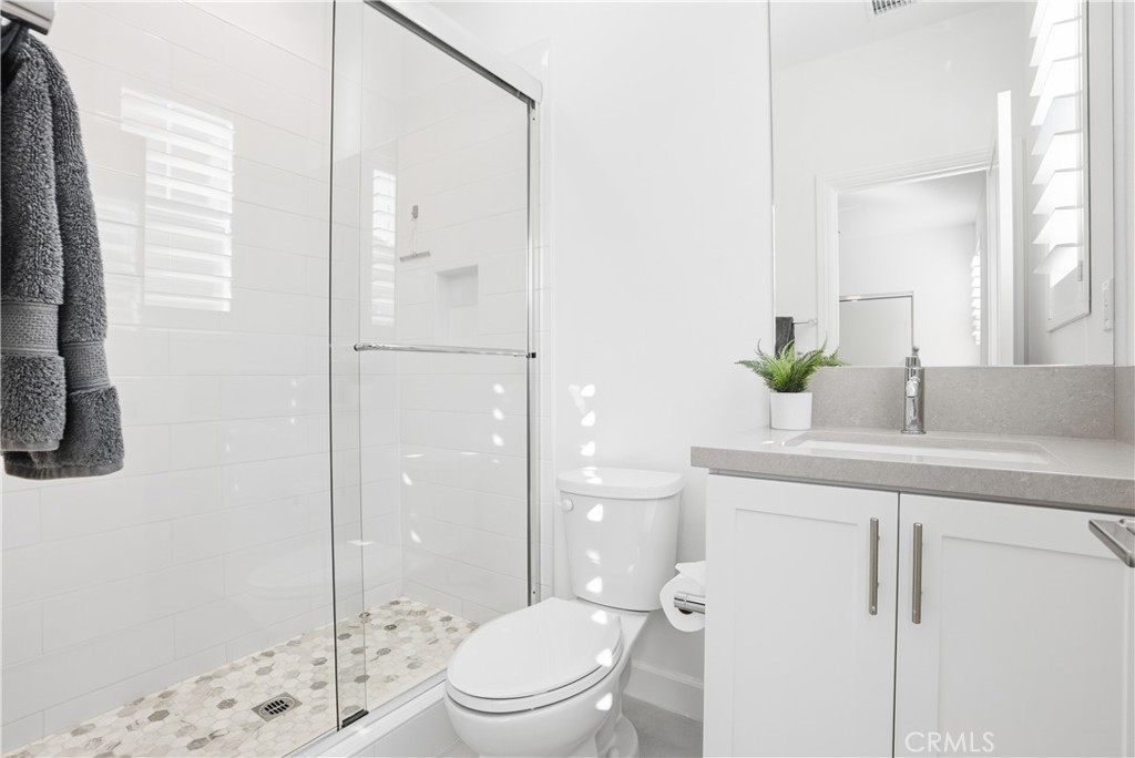 135 Medano Street Rancho Mission Viejo, CA 92694 - Photo 32 of 67 a bathroom with a granite countertop sink a toilet a mirror and shower