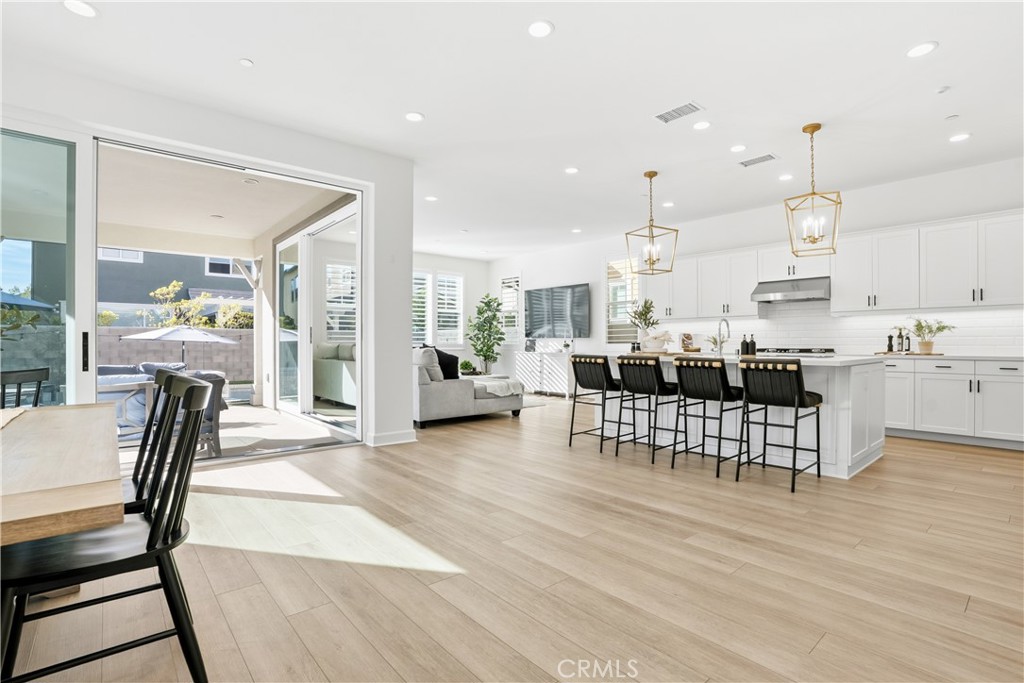 135 Medano Street Rancho Mission Viejo, CA 92694 - Photo 6 of 67 a living room with furniture and a dining table with kitchen view