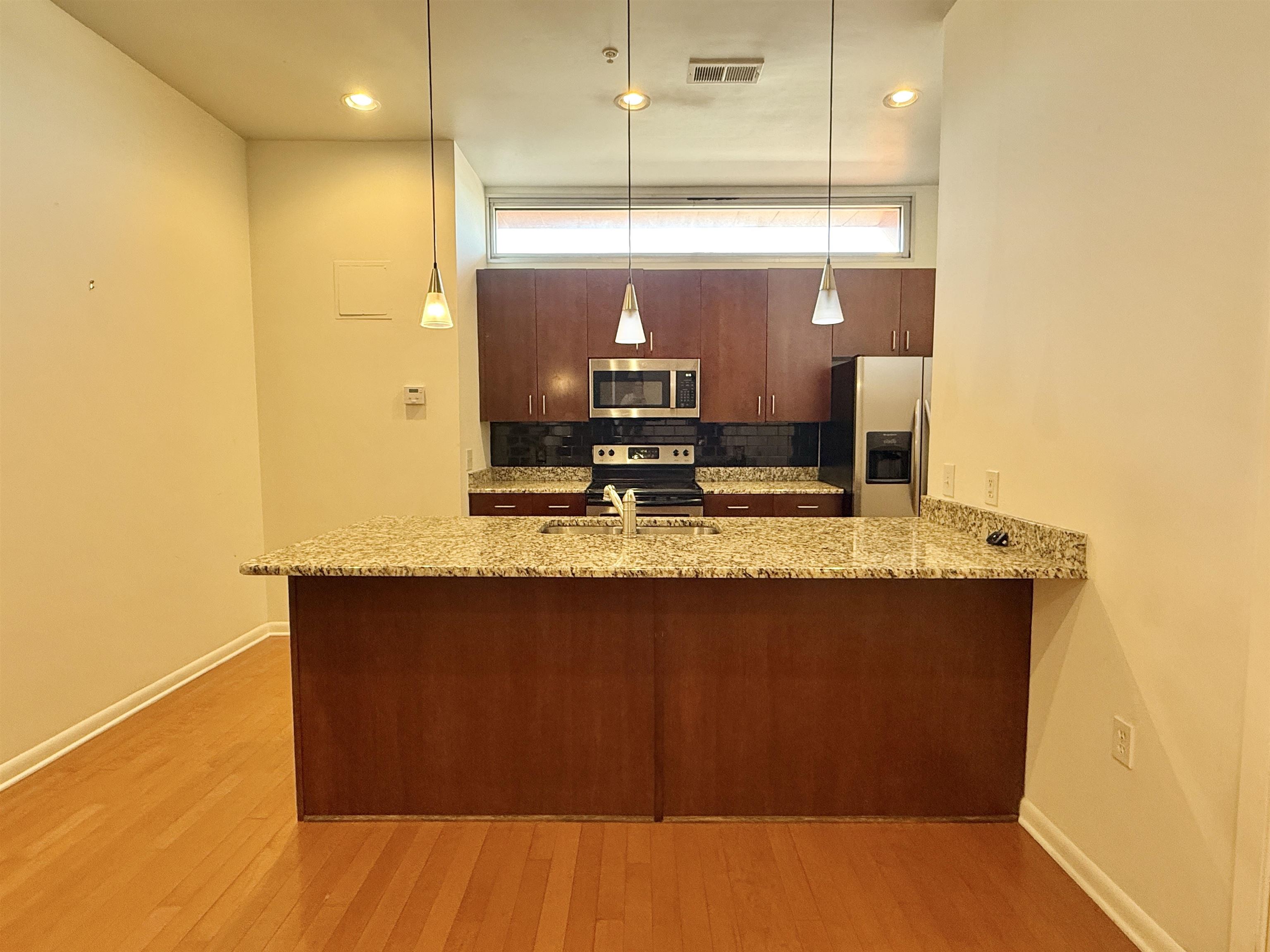 449 Monroe Avenue, Unit 104 Memphis, TN 38103 - Photo 2 of 24 a view of kitchen with stainless steel appliances granite countertop sink and wooden floor