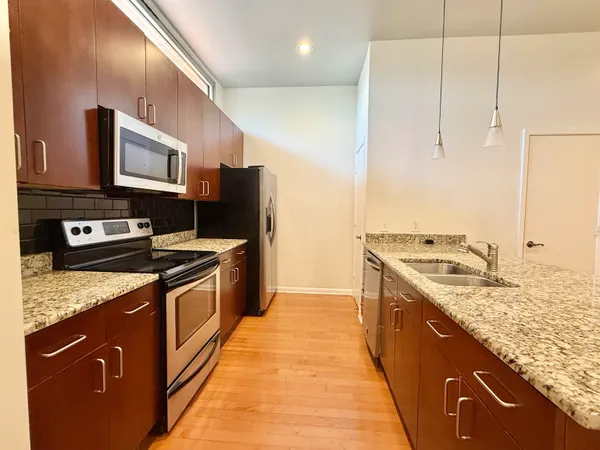 a kitchen with stainless steel appliances granite countertop a stove a sink and a refrigerator