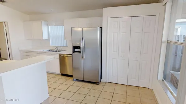a kitchen with a refrigerator a sink and cabinets