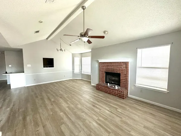 a view of an empty room with a fireplace and a window
