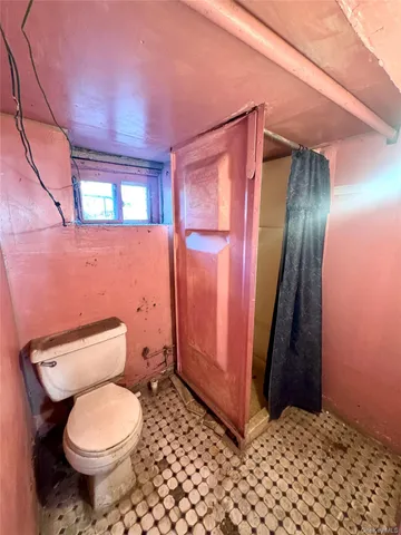 a bathroom with a toilet and a shower