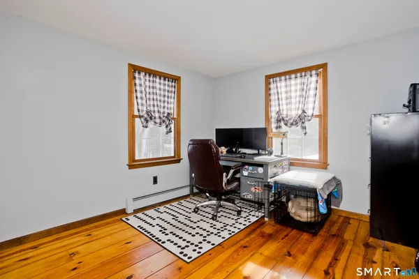 a view of a workspace with furniture and a window
