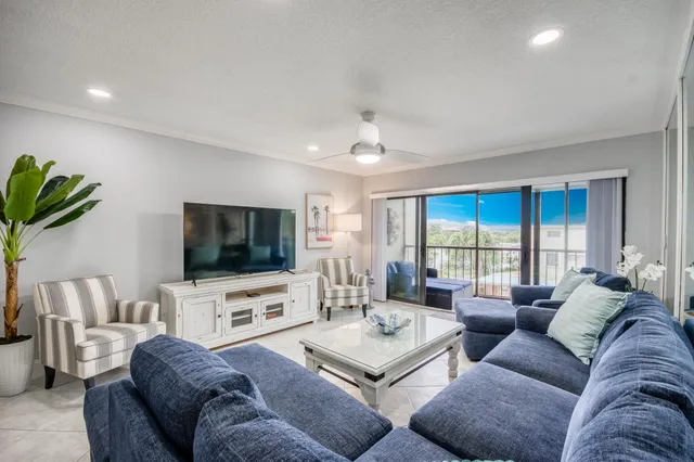 a living room with furniture a flat screen tv and a large window
