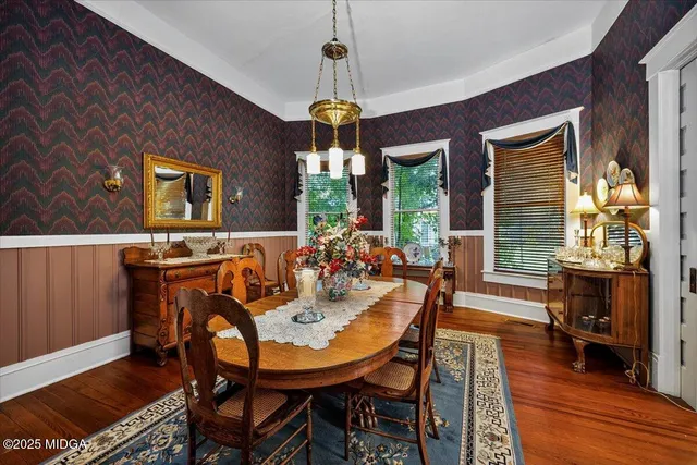 a view of a dining room with furniture a chandelier and wooden floor