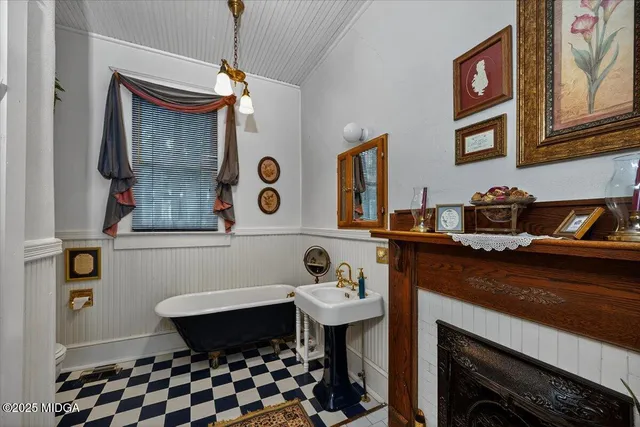 a hallway with a black white checkered floor and a book shelf
