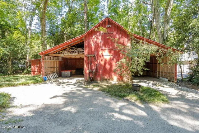 a view of a house with a small yard plants and large tree