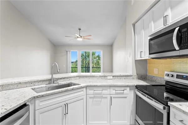 a kitchen with stainless steel appliances granite countertop a sink stove and cabinets