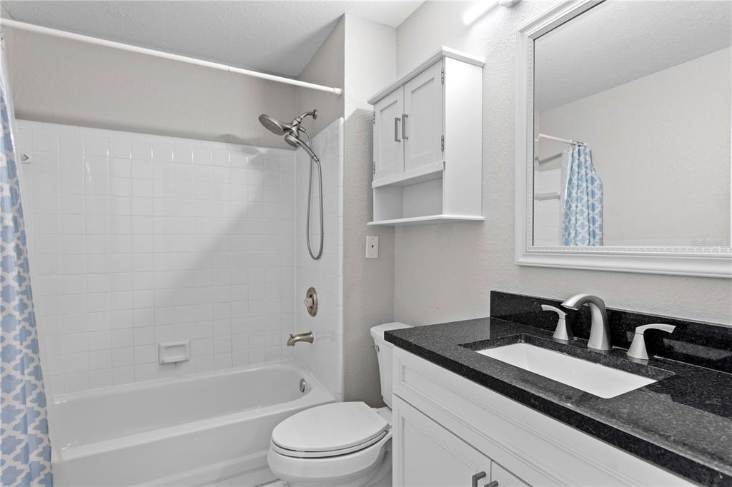 943 Normandy Trace Road Tampa, FL 33602 - Photo 14 of 51 a bathroom with a granite countertop sink toilet and shower