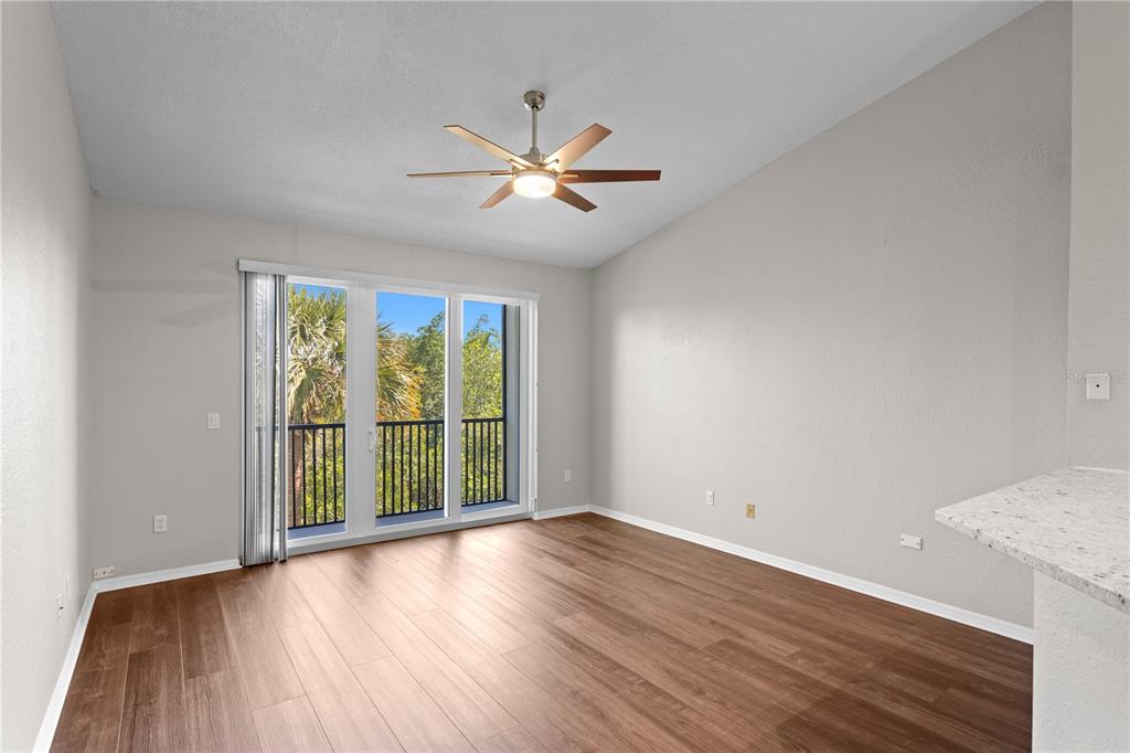 943 Normandy Trace Road Tampa, FL 33602 - Photo 15 of 51 an empty room with wooden floor fan and windows