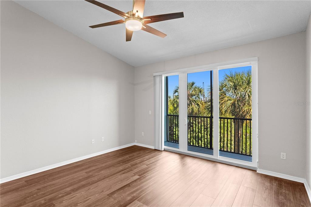 943 Normandy Trace Road Tampa, FL 33602 - Photo 19 of 51 an empty room with wooden floor fan and windows