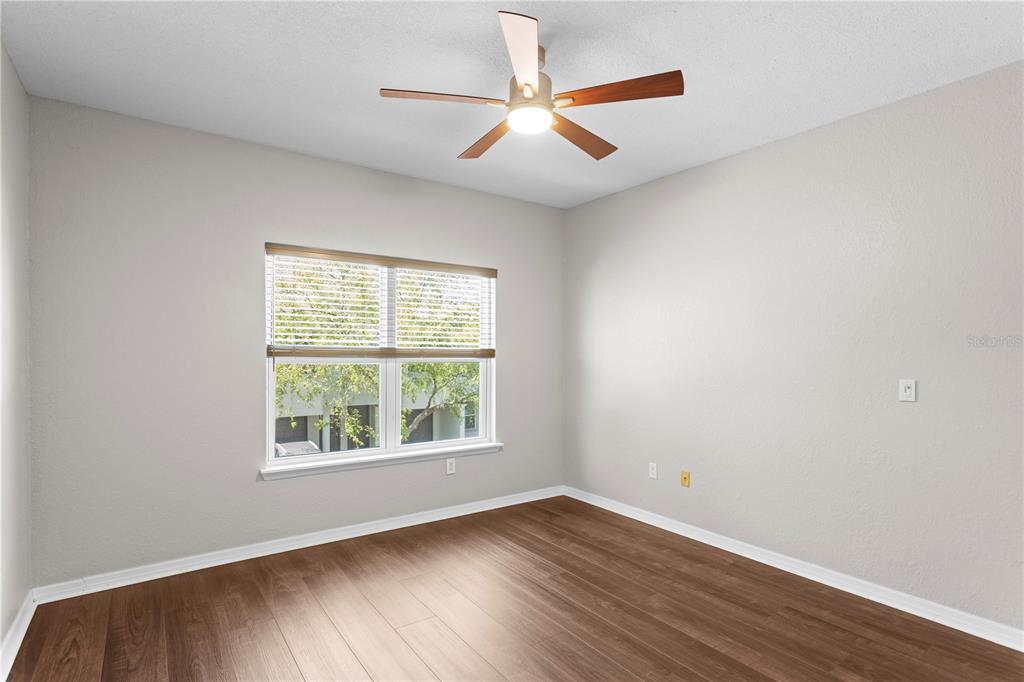943 Normandy Trace Road Tampa, FL 33602 - Photo 24 of 51 an empty room with wooden floor ceiling fan and windows