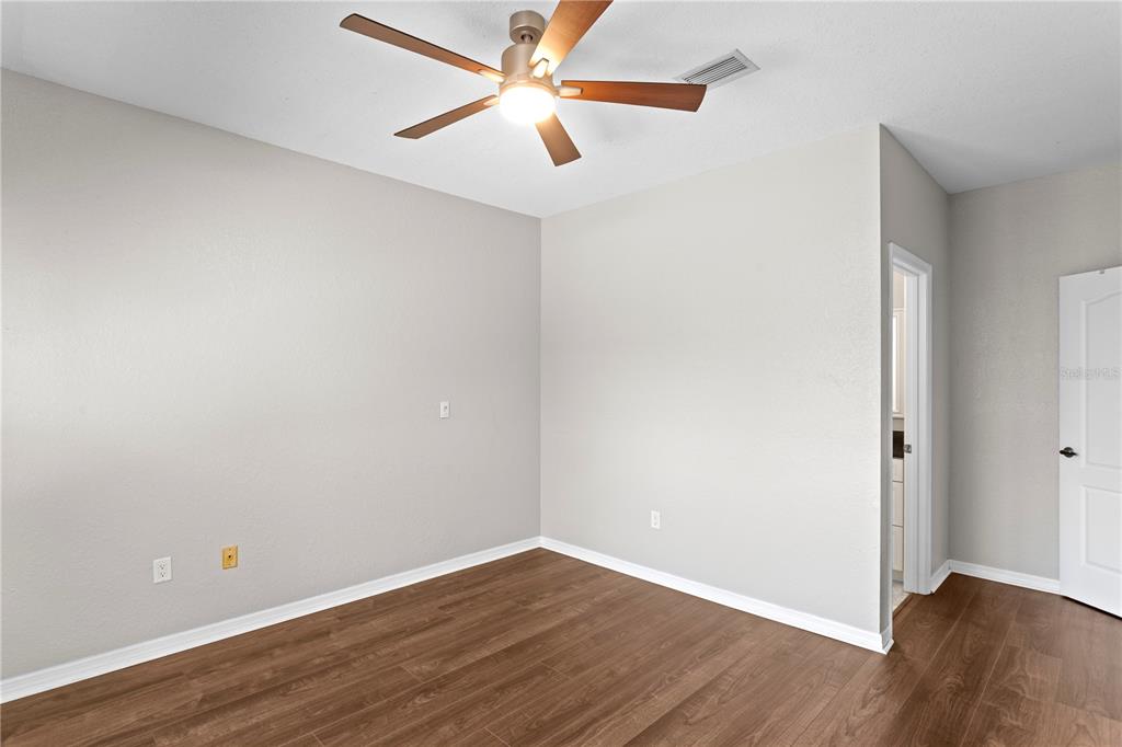 943 Normandy Trace Road Tampa, FL 33602 - Photo 25 of 51 an empty room with wooden floor and a ceiling fan