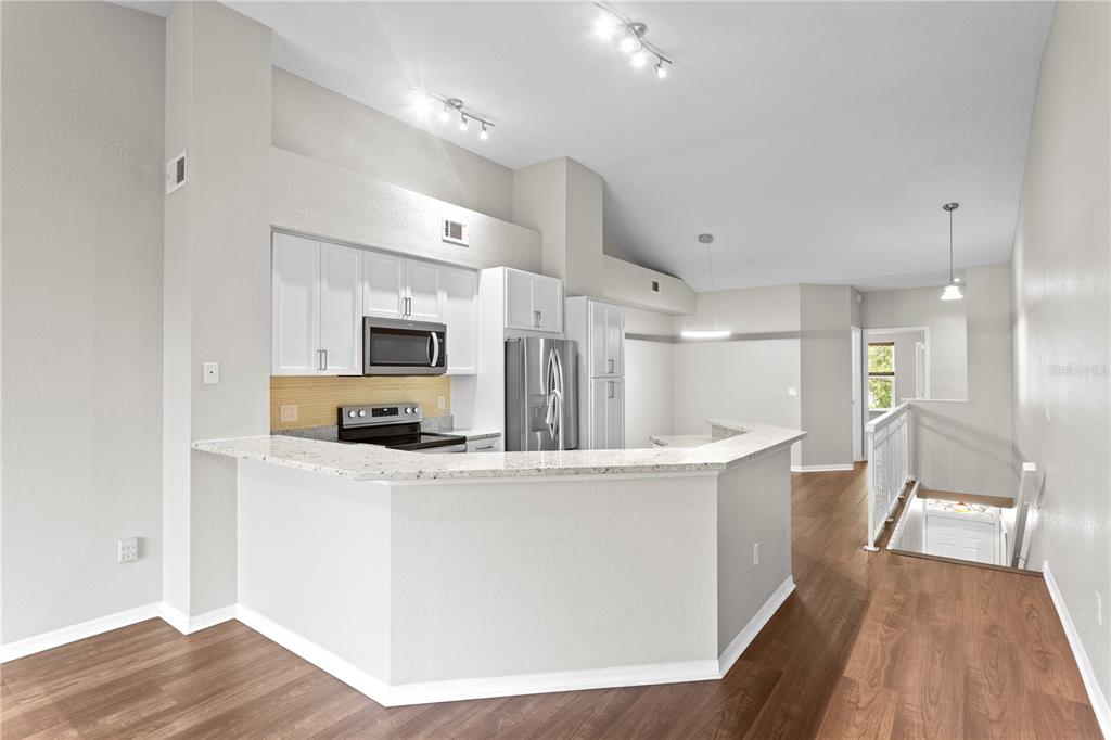943 Normandy Trace Road Tampa, FL 33602 - Photo 6 of 51 a large kitchen with stainless steel appliances kitchen island a large counter top and a wooden floors