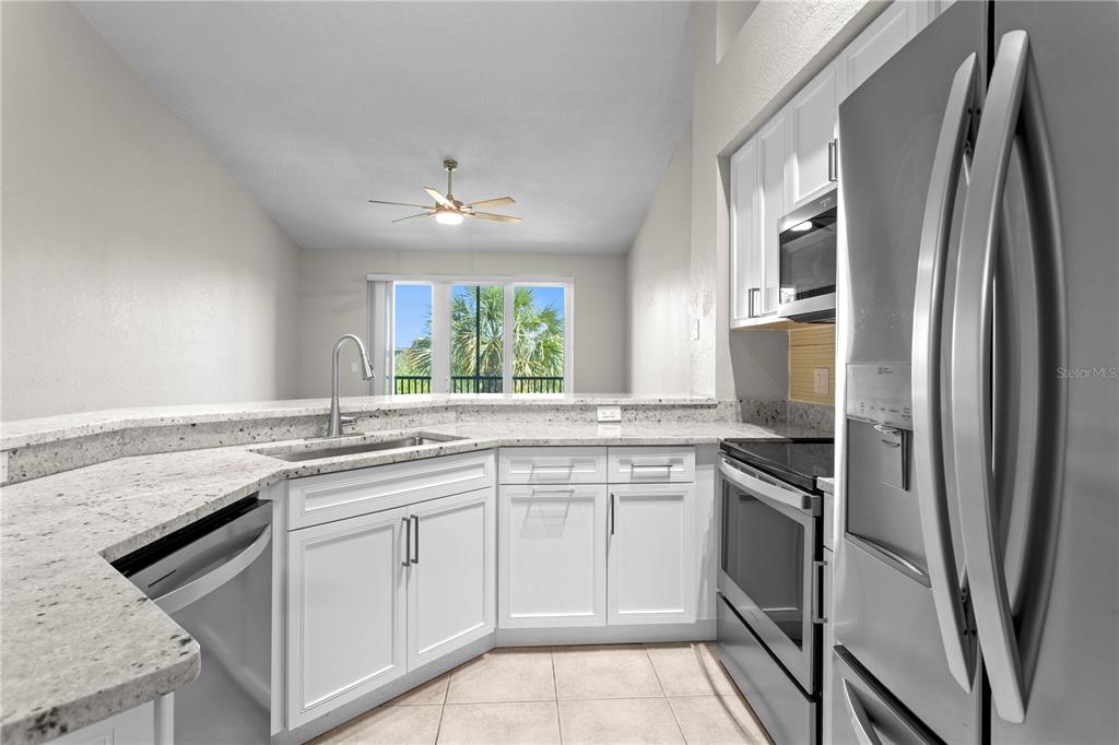 943 Normandy Trace Road Tampa, FL 33602 - Photo 10 of 51 a kitchen with stainless steel appliances granite countertop a sink stove and refrigerator