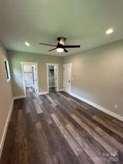 an empty room with ceiling fan and window