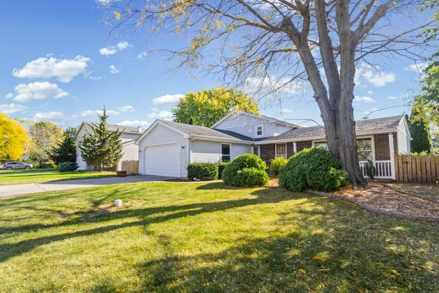 a front view of a house with a garden and trees