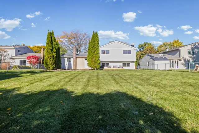 a view of a house with a big yard and large trees