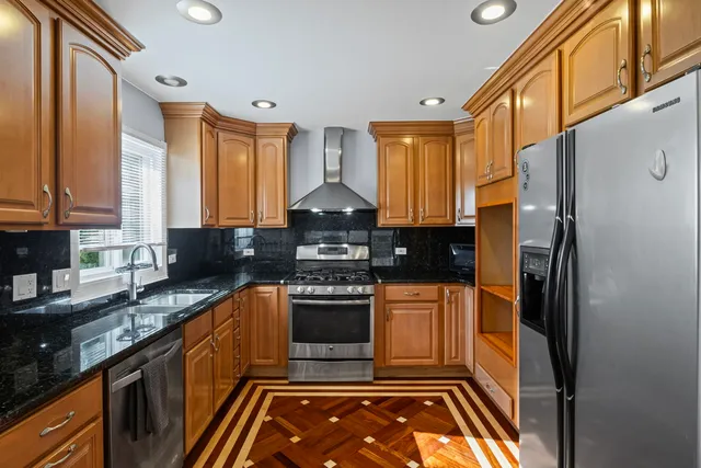a kitchen with stainless steel appliances granite countertop a stove a sink and a refrigerator