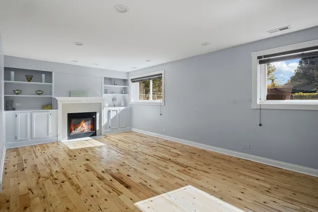 a view of a livingroom with wooden floor and a fireplace