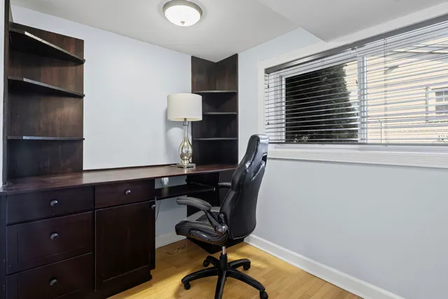a view of a workspace with furniture and a window