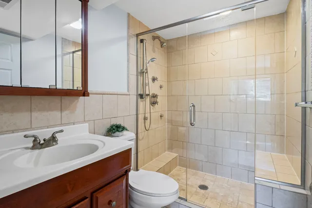 a bathroom with a sink a toilet and shower