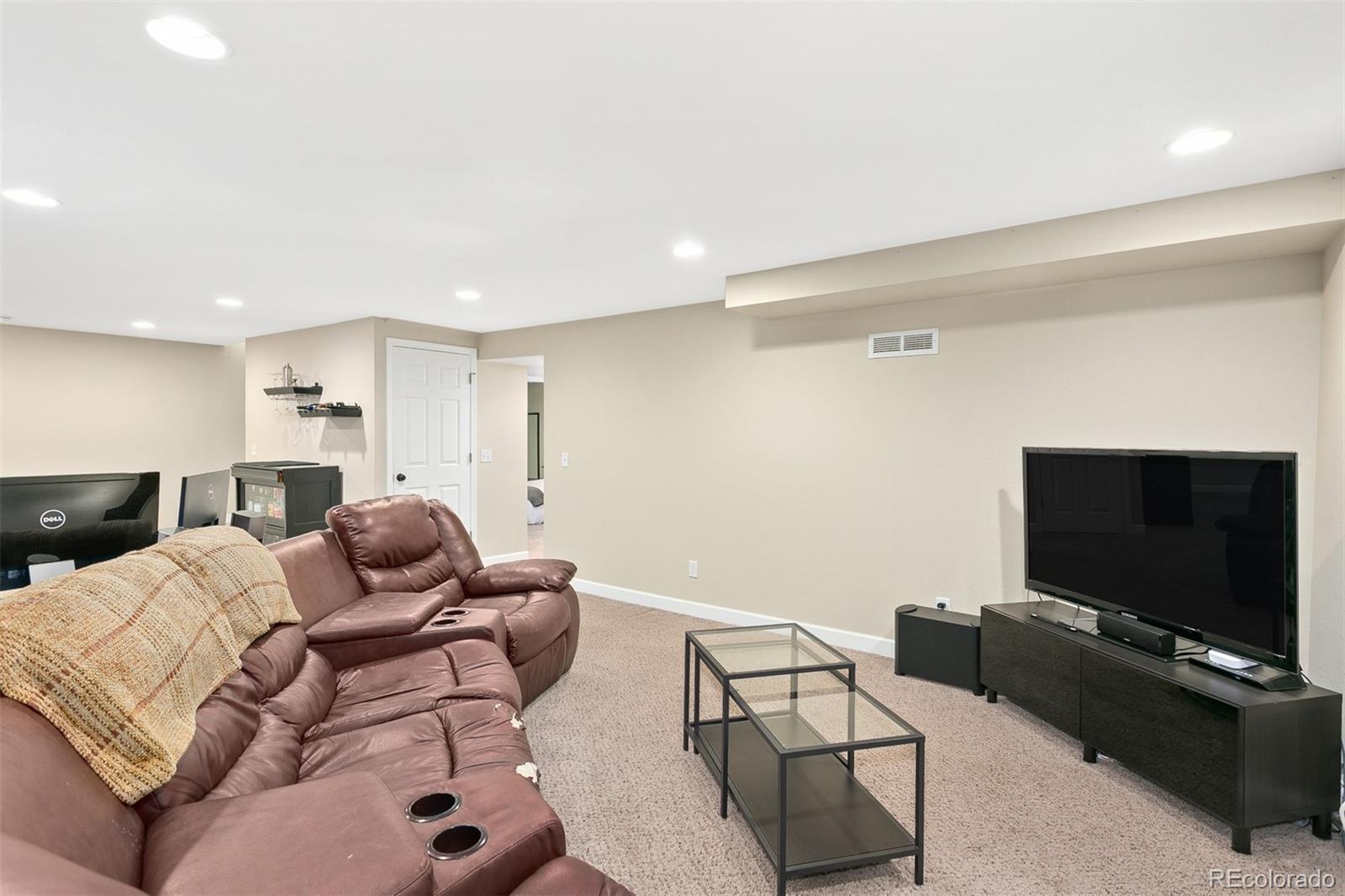 4139 East 131st Drive Thornton, CO 80241 - Photo 16 of 29 a living room with furniture and a flat screen tv