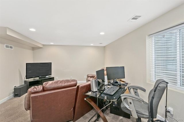 a view of a workspace with furniture and a window