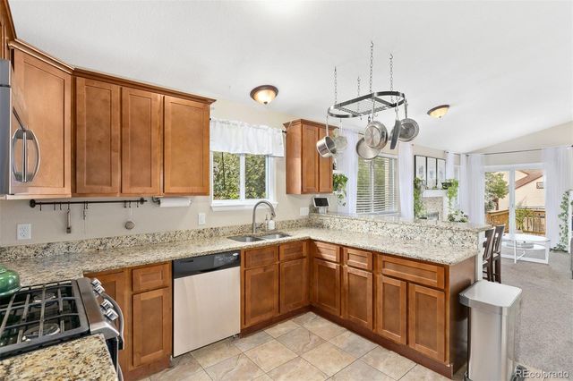 a kitchen with stainless steel appliances granite countertop a sink and a stove