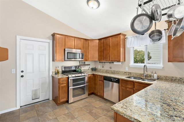 a kitchen with stainless steel appliances granite countertop a sink and a stove