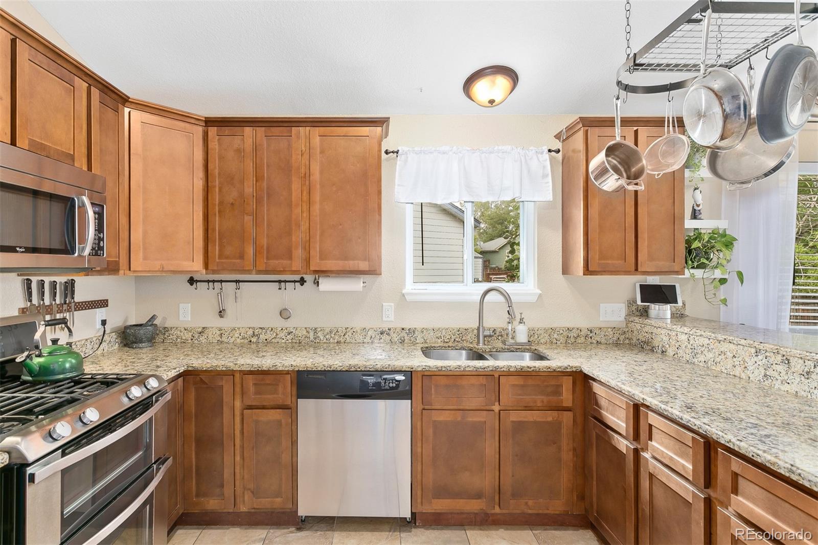 4139 East 131st Drive Thornton, CO 80241 - Photo 9 of 29 a kitchen with stainless steel appliances granite countertop a sink a stove and a microwave