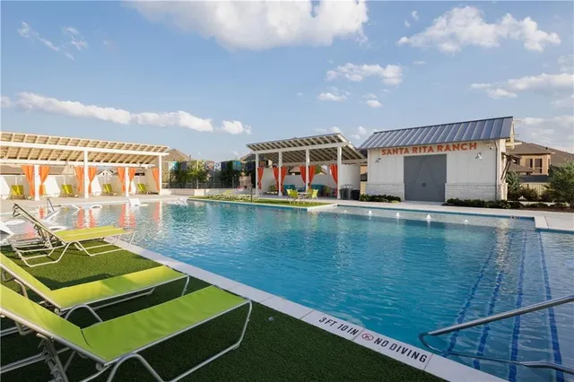an outdoor view of house with swimming pool and chairs