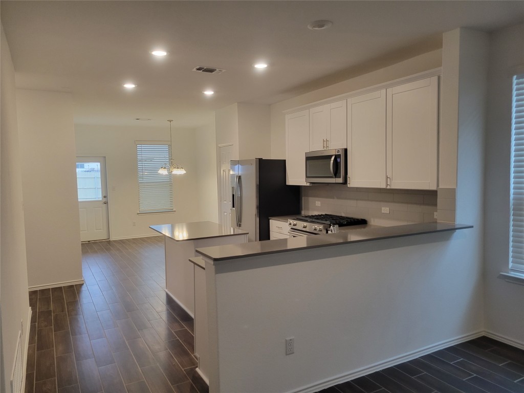 549 Pickrell Loop Georgetown, TX 78628 - Photo 5 of 26 a kitchen with granite countertop a sink and a stove top oven