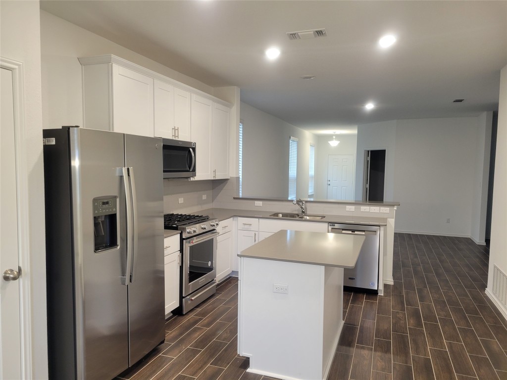 549 Pickrell Loop Georgetown, TX 78628 - Photo 6 of 26 a kitchen with kitchen island a sink stove and refrigerator