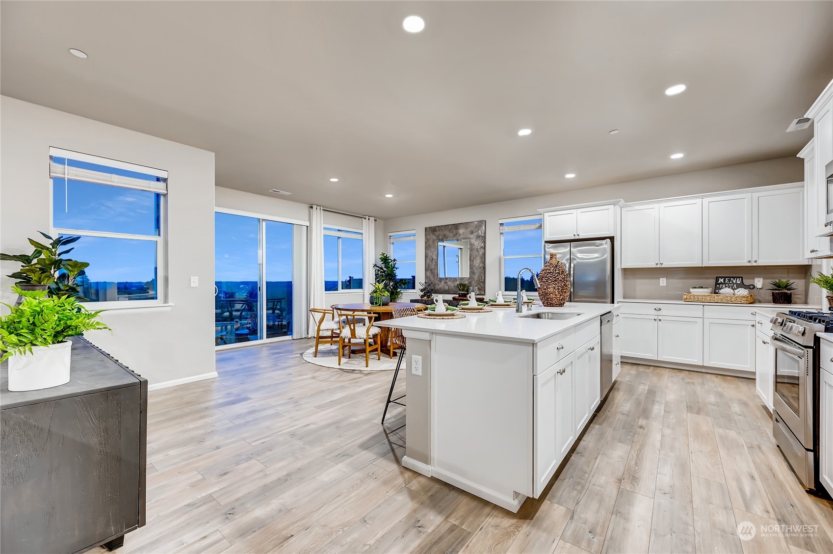 4393 Reef Road Southwest, Unit 3047 Port Orchard, WA 98367 - Photo 12 of 27 a kitchen with stainless steel appliances kitchen island granite countertop a stove top oven a sink a dining table and chairs