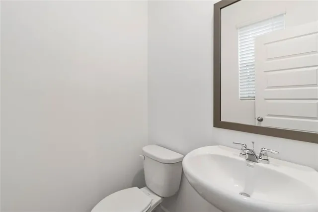 a bathroom with a toilet a sink and mirror